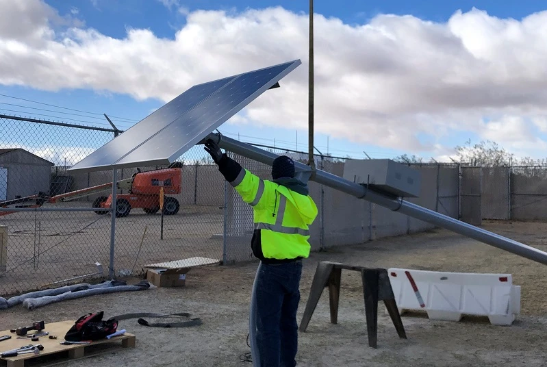 Solar street light installation site showing engineering team maintenance to prevent rainy season failures