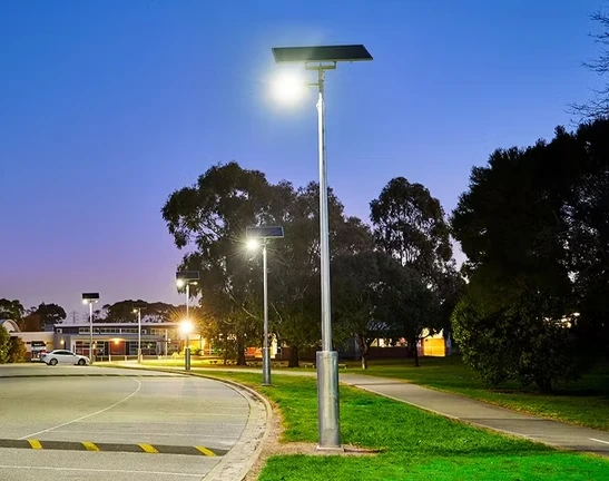 Solar street light project installation along roadway at dusk